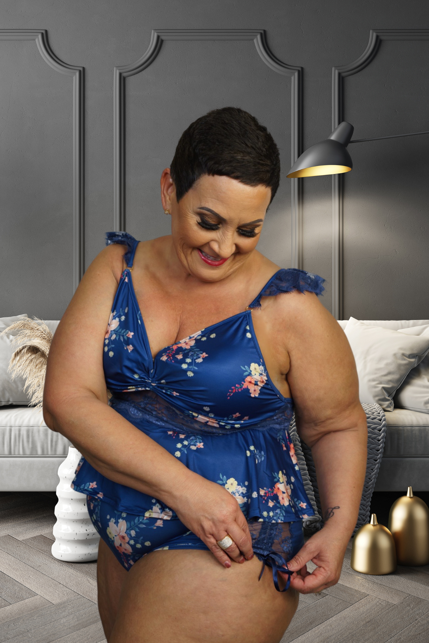 Plus size woman wearing blue Bella floral lingerie with ruffle details in a modern living room
