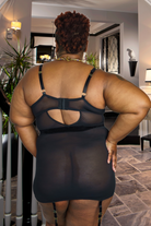 Plus size model wearing daring camo lingerie black sheer back with adjustable straps in a modern room