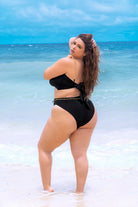 Plus size model wearing CT Lingerie lyra sexy black bikini standing on the beach 