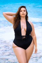 CT Lingerie Tawny dip low one piece plus size swimsuit in black with lace-up waist detail on beach